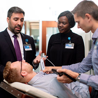 Three clinicians provide care to a patient